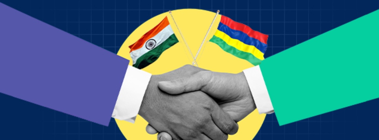 Illustration of two hands shaking to symbolize a bilateral agreement, with the Indian flag and Mauritian flag crossed above the handshake against a blue background.